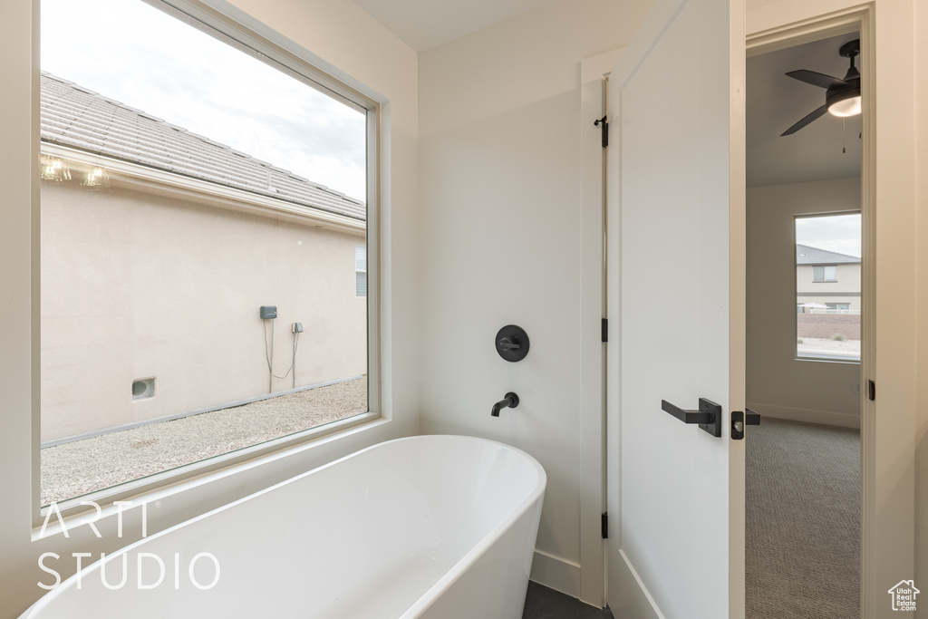 Bathroom with a washtub and ceiling fan