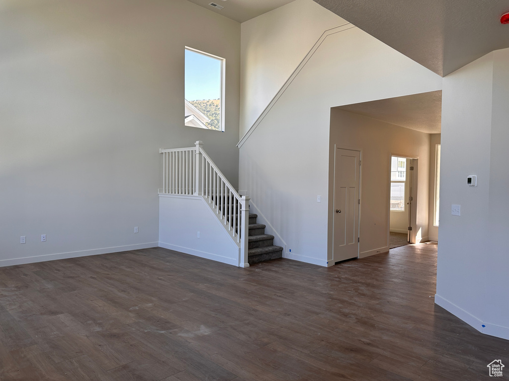 Spare room with dark hardwood / wood-style flooring and a healthy amount of sunlight