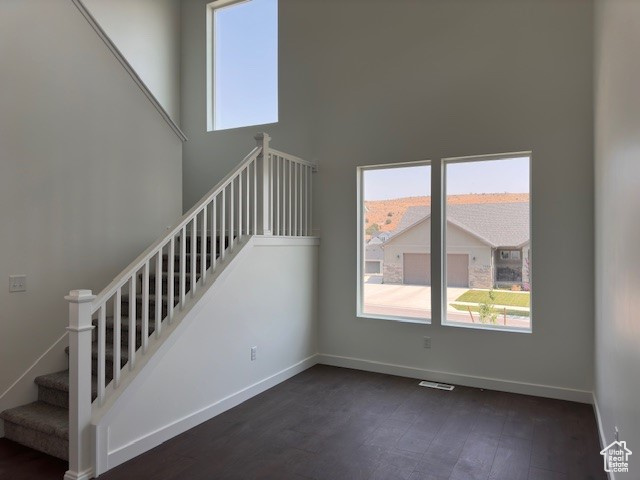 Staircase featuring a high ceiling and hardwood / wood-style flooring