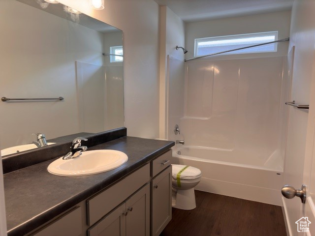 Full bathroom featuring vanity, toilet, shower / bathing tub combination, and hardwood / wood-style floors