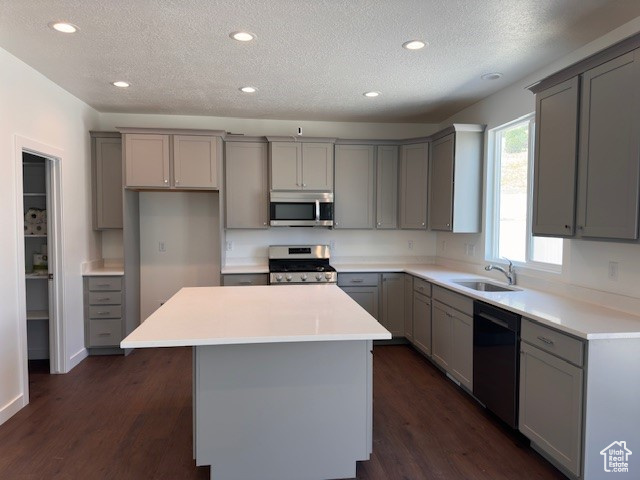 Kitchen with range, sink, black dishwasher, dark hardwood / wood-style floors, and a kitchen island