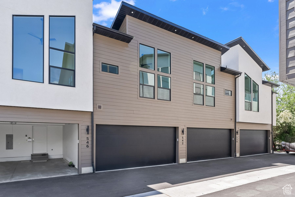 View of front of house featuring a garage and electric panel