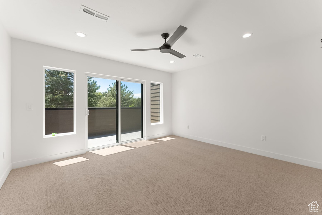 Carpeted empty room featuring ceiling fan