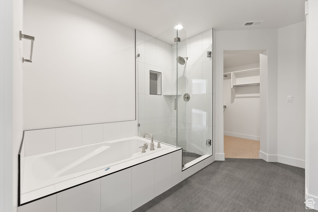 Bathroom with independent shower and bath and tile patterned floors