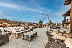 View of patio featuring an outdoor living space with a fire pit