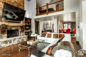 Living room featuring a high ceiling, a fireplace, and hardwood / wood-style flooring