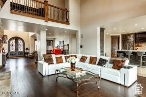 Living room with dark hardwood / wood-style flooring, french doors, and a towering ceiling