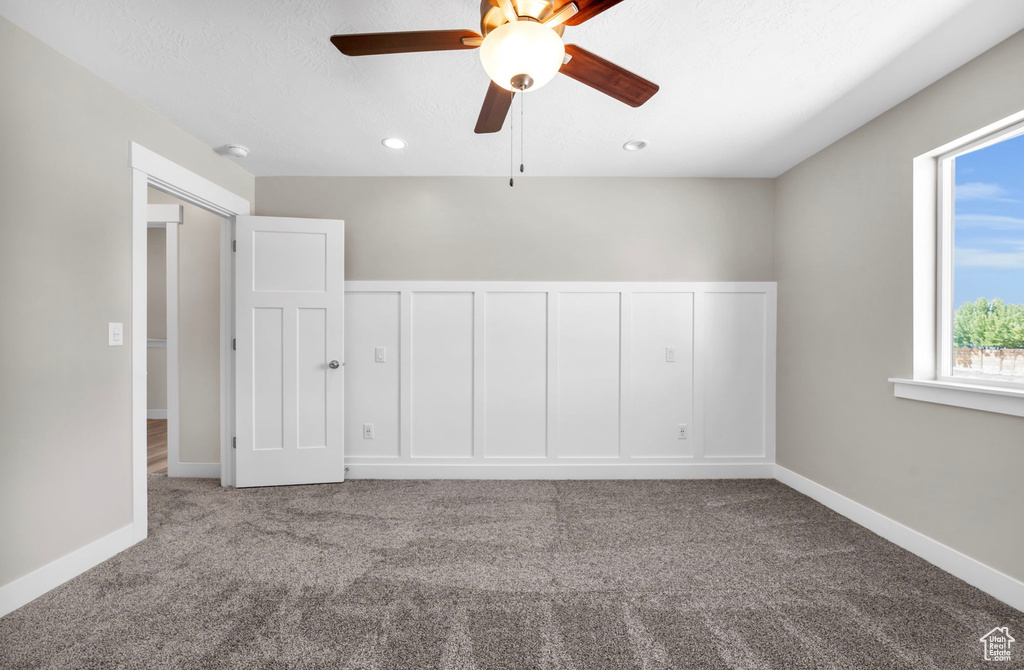 Carpeted empty room featuring ceiling fan