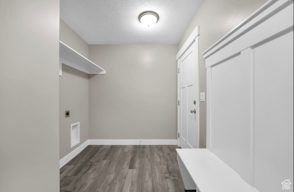 Laundry room featuring electric dryer hookup, a textured ceiling, and hardwood / wood-style flooring