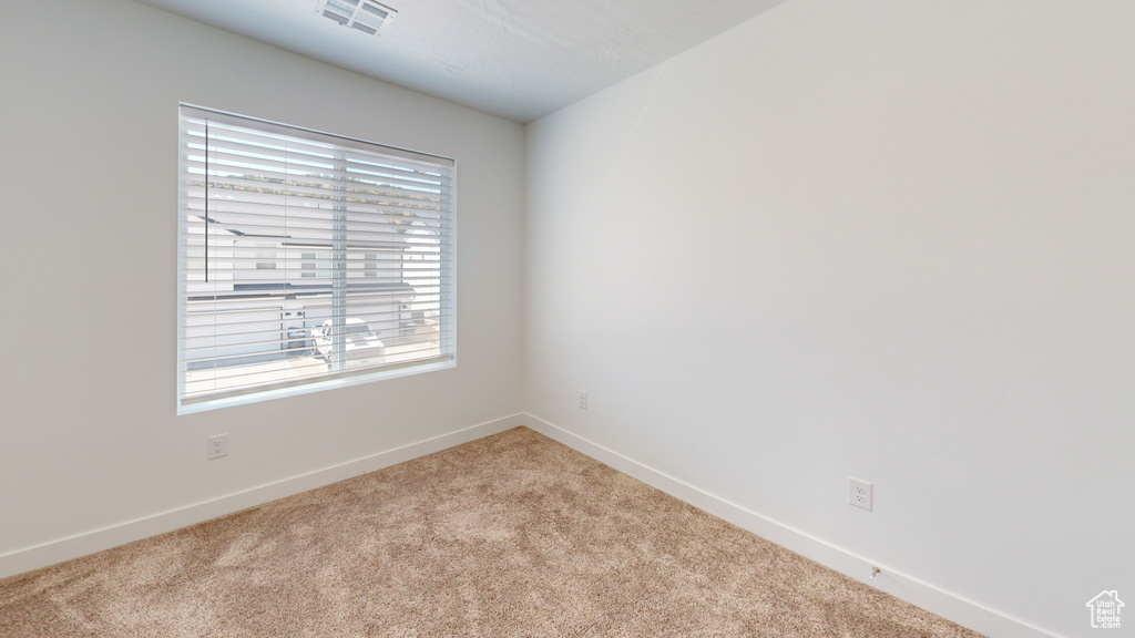 Spare room with light carpet and a wealth of natural light