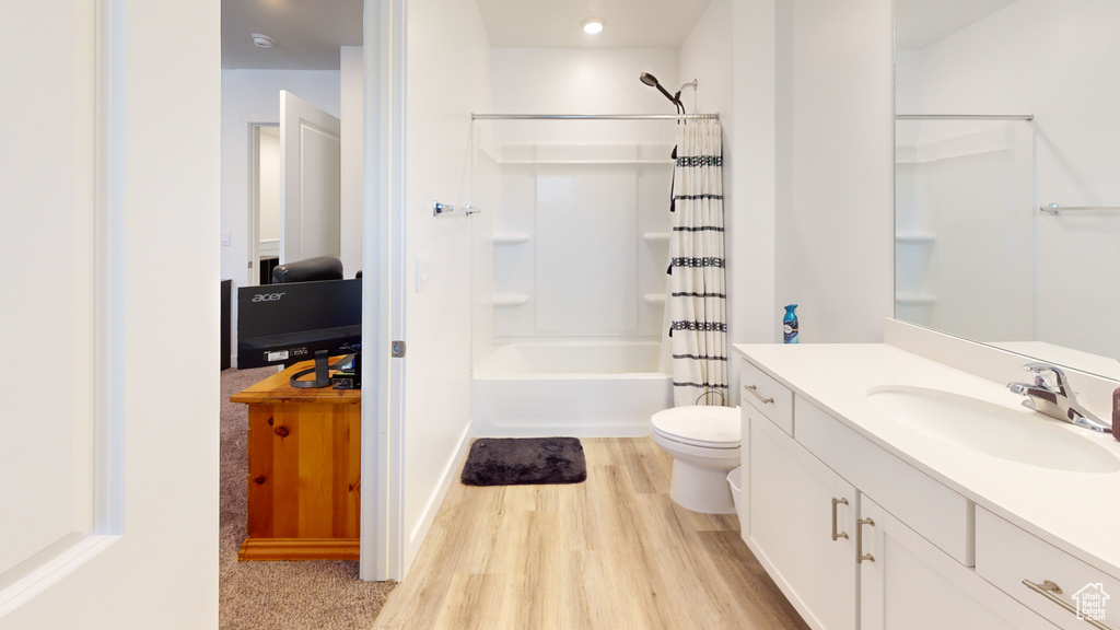 Full bathroom featuring vanity, hardwood / wood-style flooring, toilet, and shower / tub combo with curtain