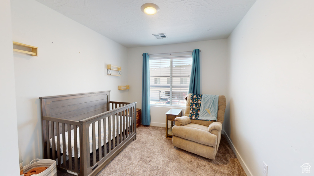 Carpeted bedroom with a crib