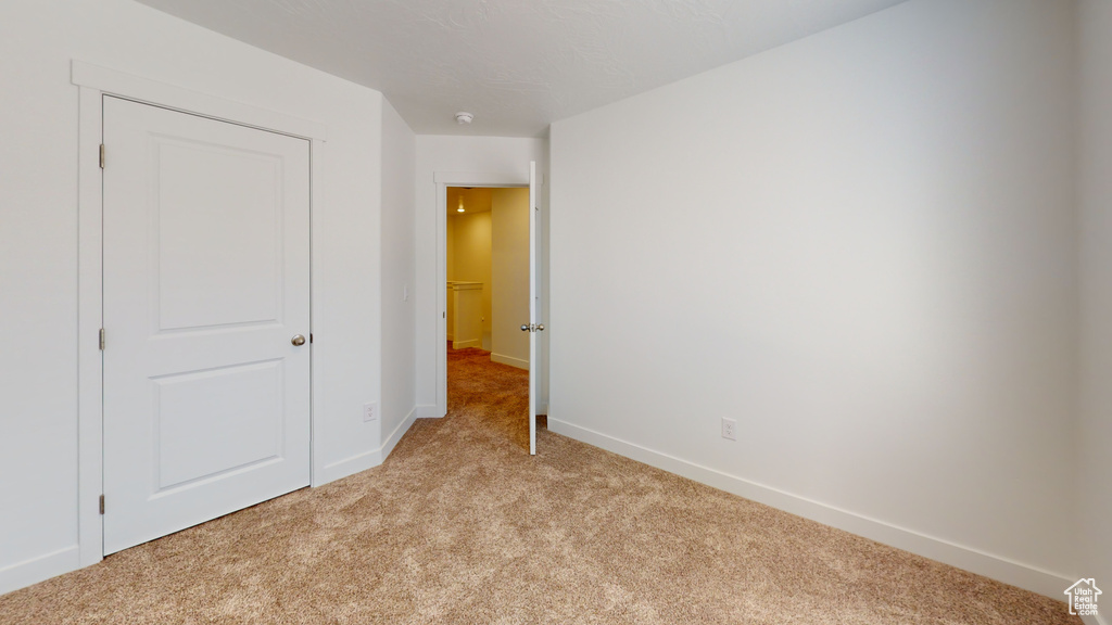 Unfurnished bedroom with light colored carpet