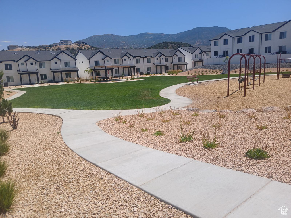 View of home's community featuring a playground, a yard, and a mountain view