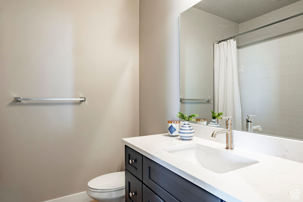 Bathroom with toilet, vanity, and a textured ceiling