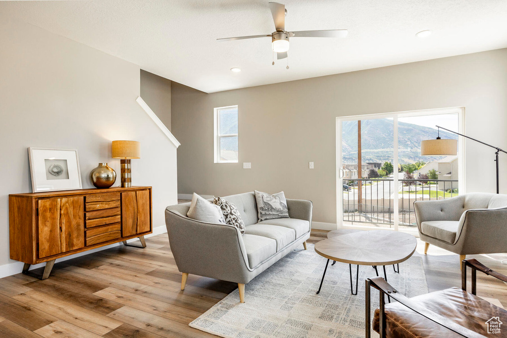 Living room with ceiling fan, light hardwood / wood-style flooring, and a mountain view