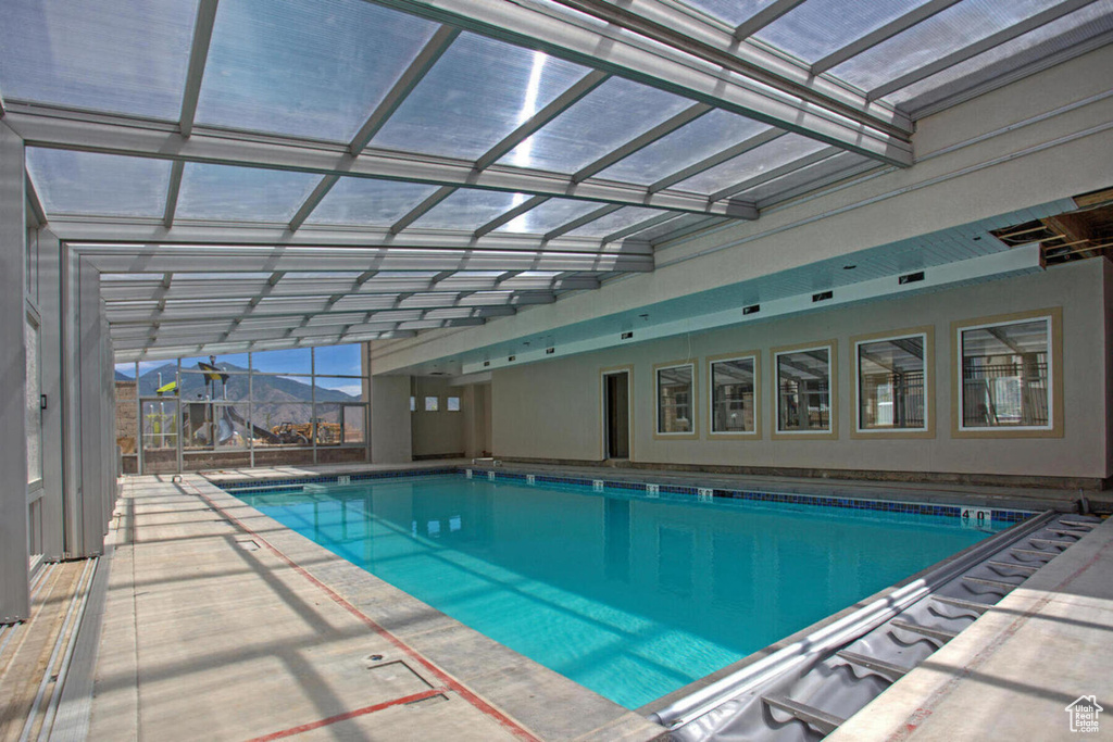 View of pool with a mountain view, a patio, and a lanai