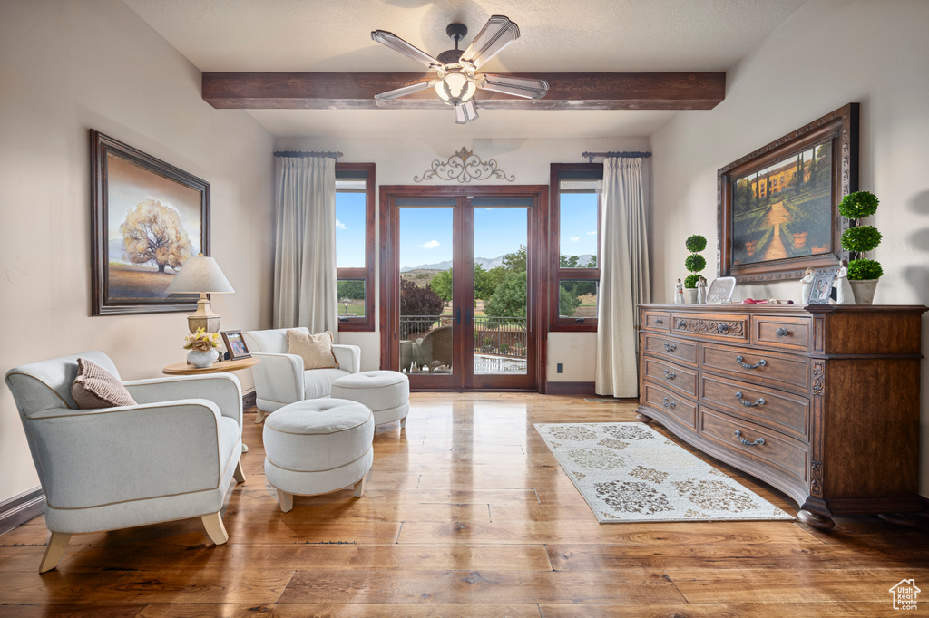 Living room with beamed ceiling, french doors, ceiling fan, and light hardwood / wood-style floors