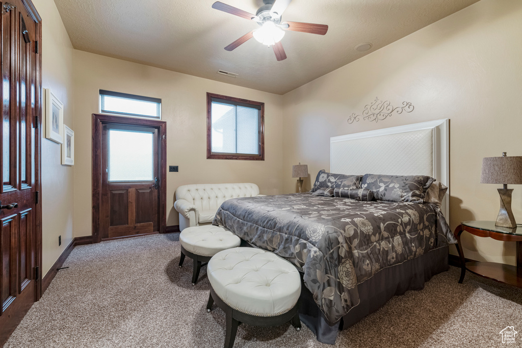 Carpeted bedroom featuring ceiling fan