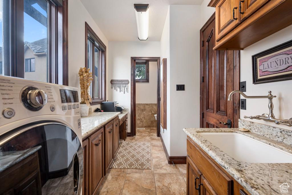 Bathroom featuring washer / dryer, tile patterned floors, and vanity