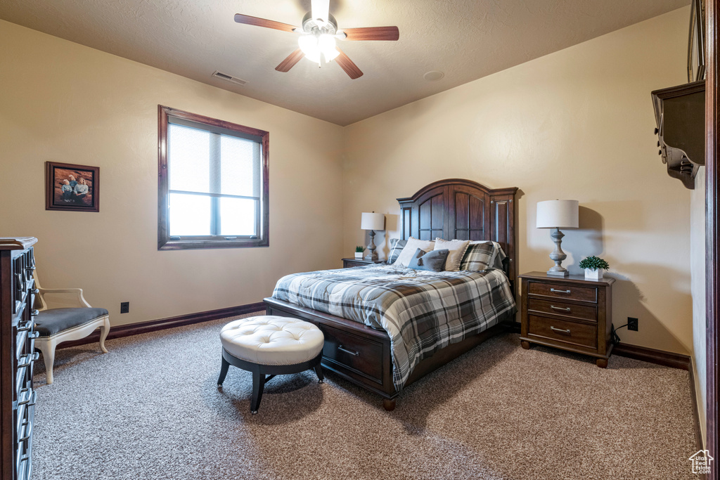 Carpeted bedroom featuring ceiling fan