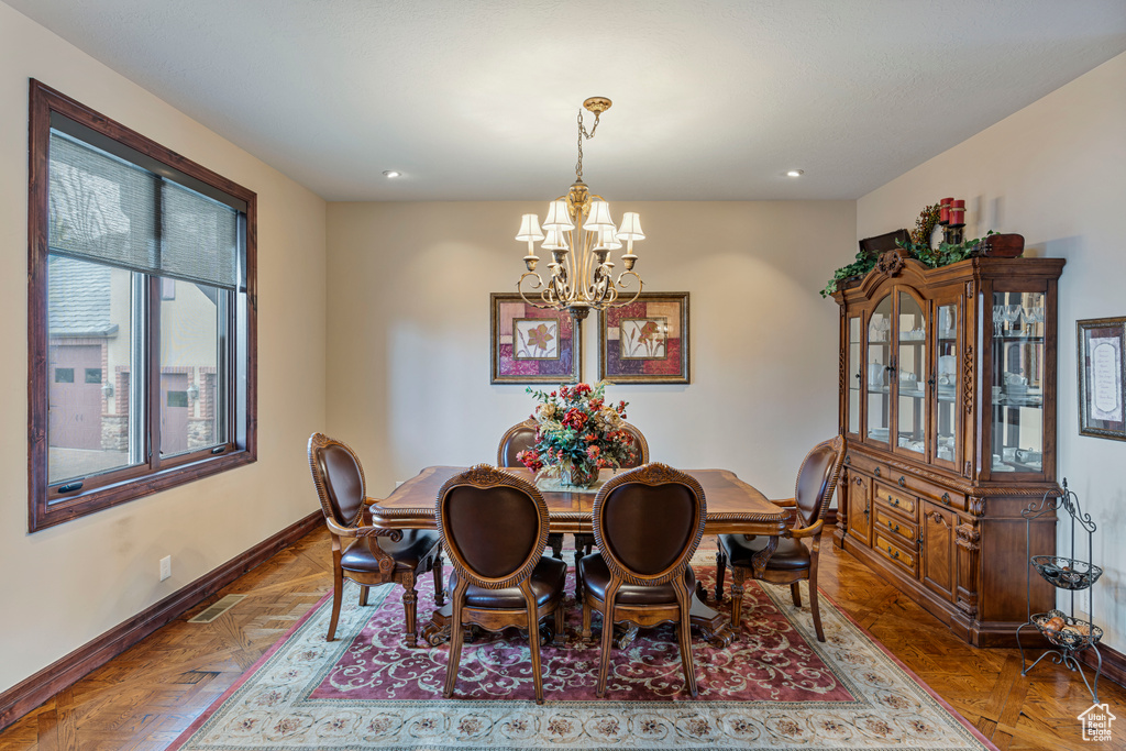 Dining space with parquet floors and an inviting chandelier