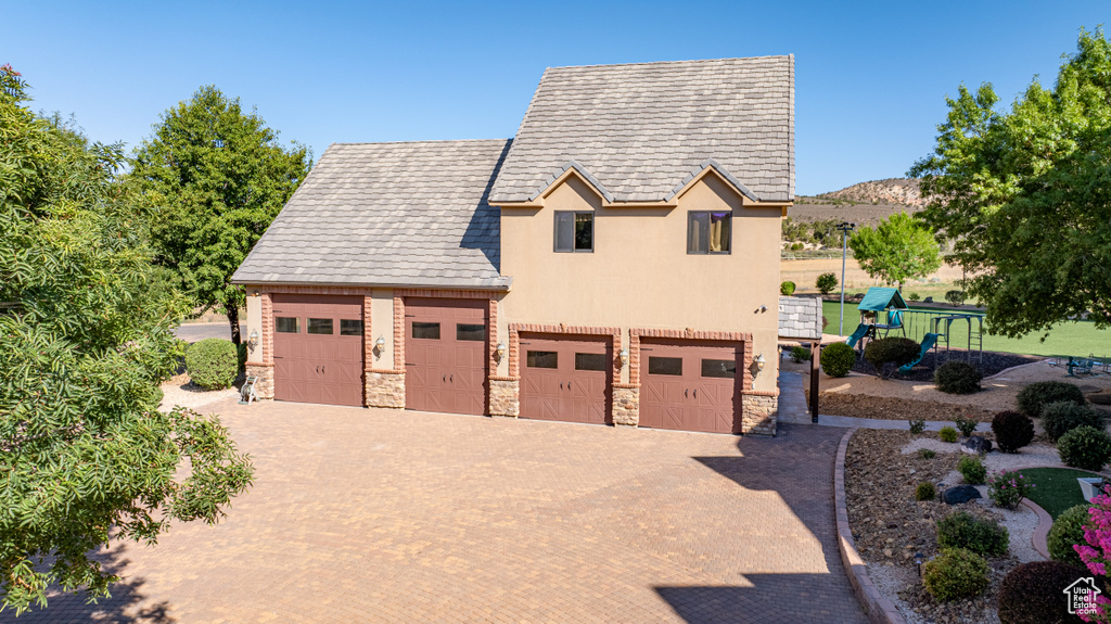 View of front of house featuring a garage and a playground