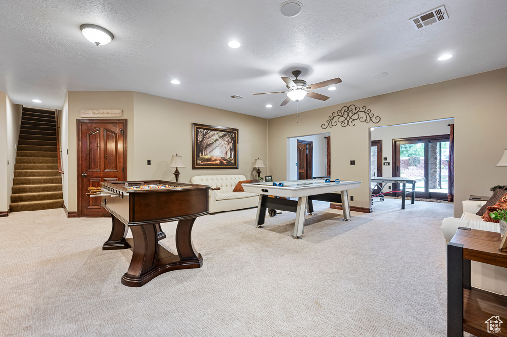 Recreation room with light carpet, a textured ceiling, and ceiling fan