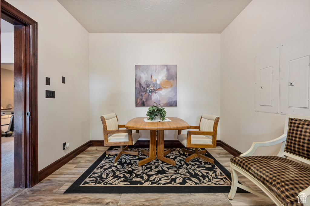 Dining area with electric panel and hardwood / wood-style floors