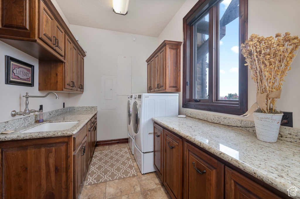 Laundry area with sink, cabinets, light tile patterned floors, independent washer and dryer, and electric panel