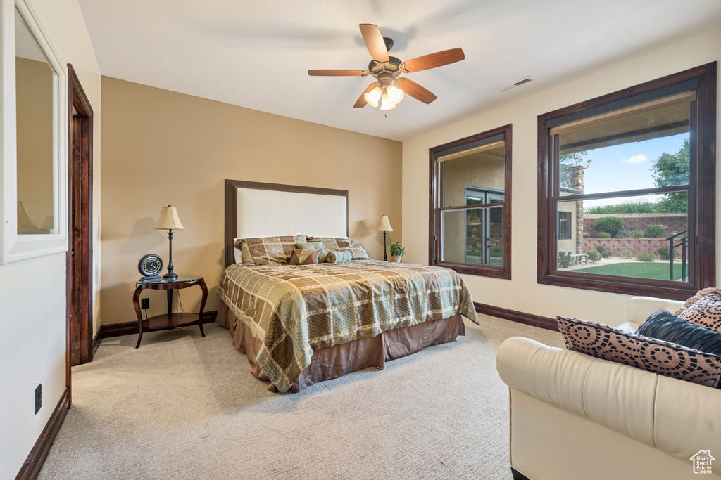 Carpeted bedroom featuring ceiling fan