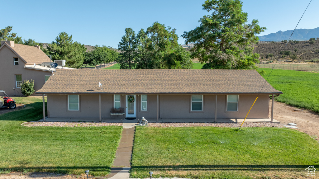 Single story home with a patio area, a mountain view, and a front yard