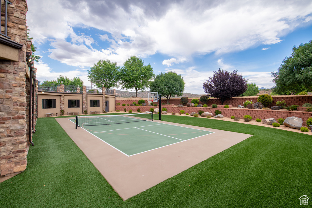 View of sport court with a yard