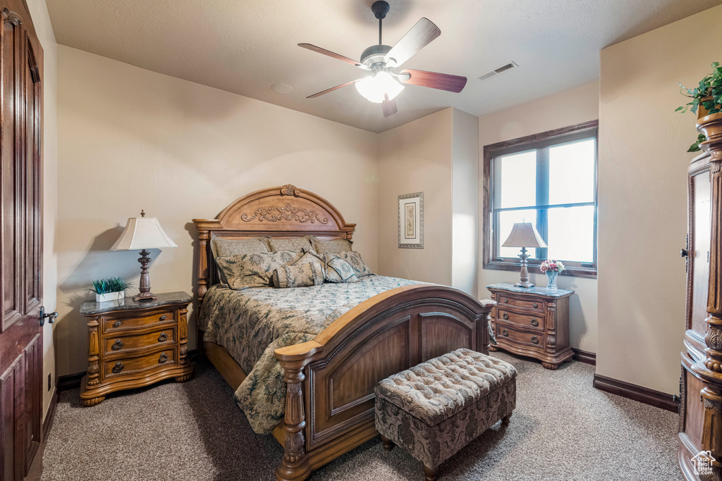 Bedroom with ceiling fan and light colored carpet