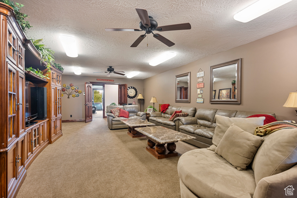 Carpeted living room featuring a textured ceiling and ceiling fan