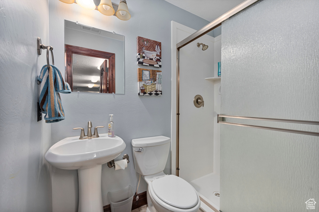 Bathroom with a shower with shower door and toilet