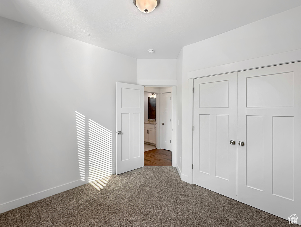 Unfurnished bedroom featuring a closet and carpet