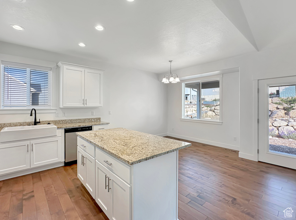 Kitchen featuring plenty of natural light, dishwasher, sink, and a center island