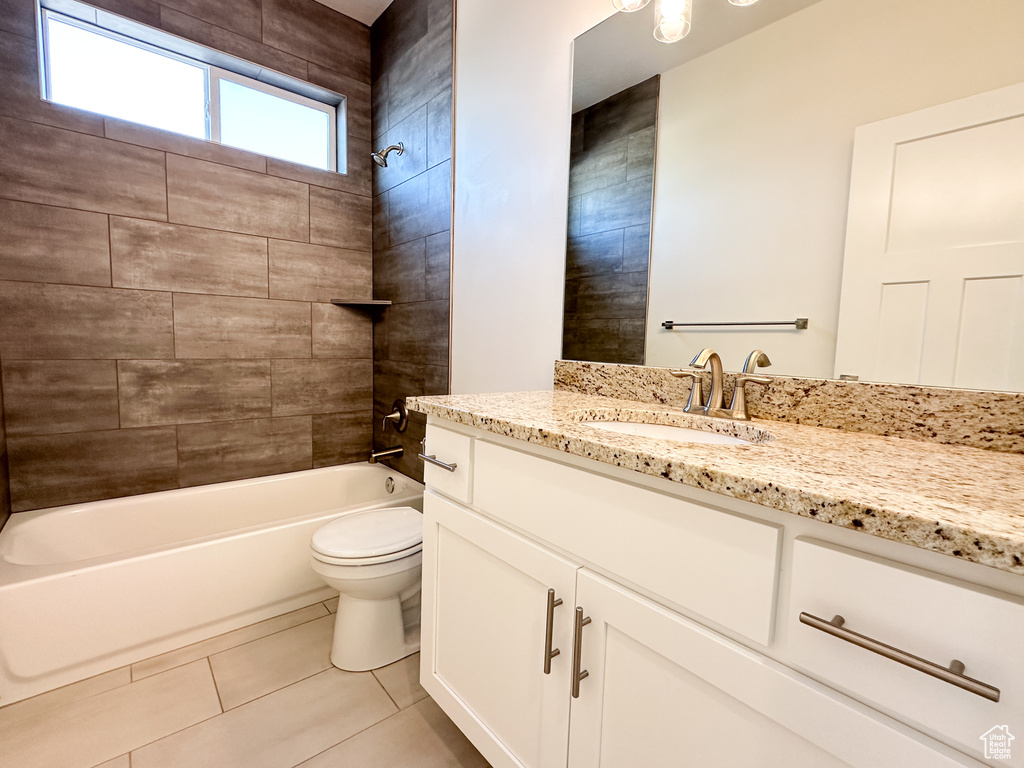 Full bathroom with tile patterned floors, tiled shower / bath, toilet, and vanity