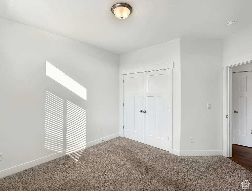 Unfurnished bedroom with a closet and carpet