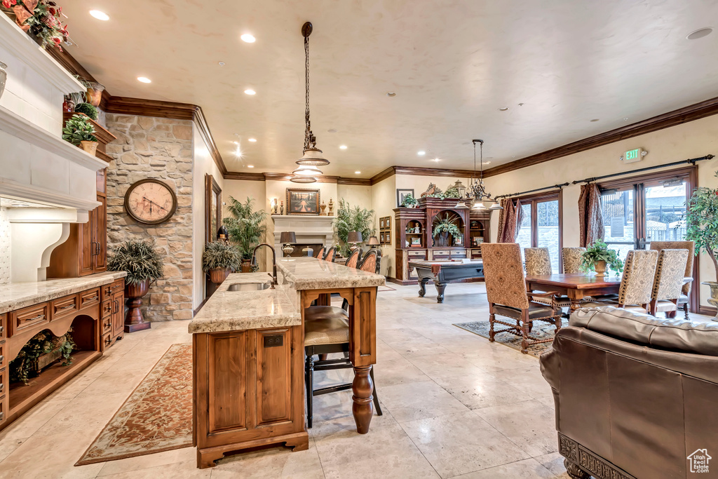 Tiled dining space with sink and crown molding