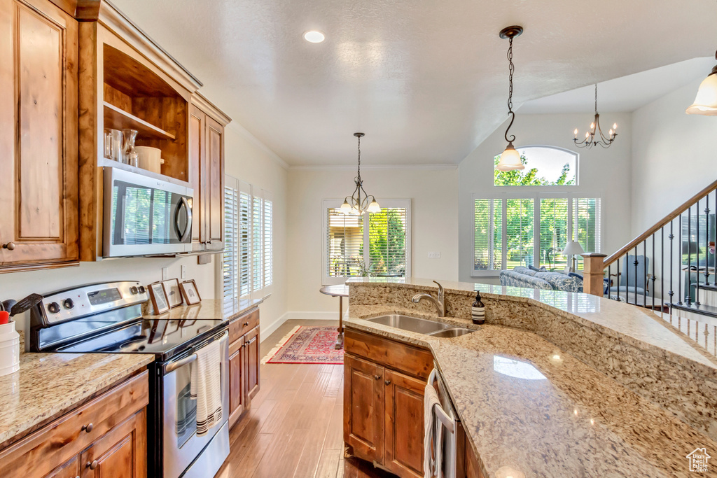 Kitchen with sink, appliances with stainless steel finishes, a healthy amount of sunlight, and light wood-type flooring