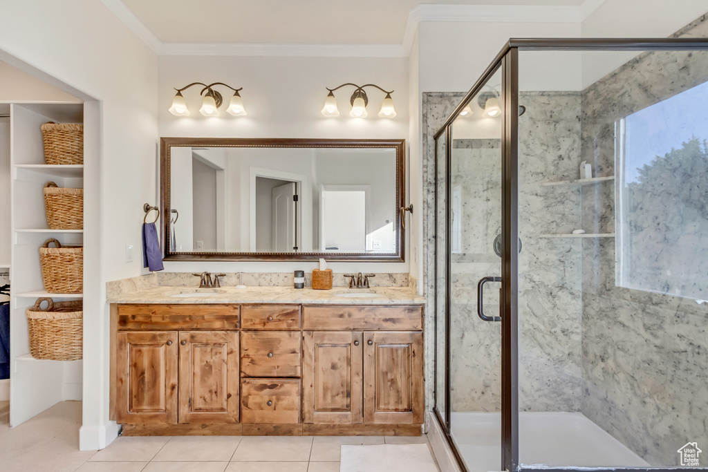 Bathroom with tile patterned flooring, dual vanity, walk in shower, and crown molding