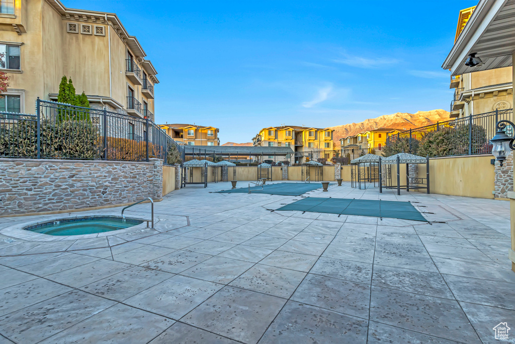 View of swimming pool with a patio and a community hot tub