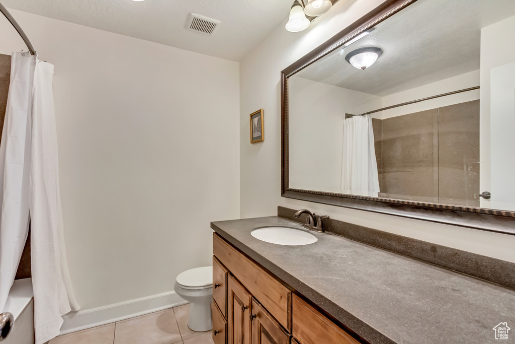 Bathroom with tile patterned floors, toilet, and vanity