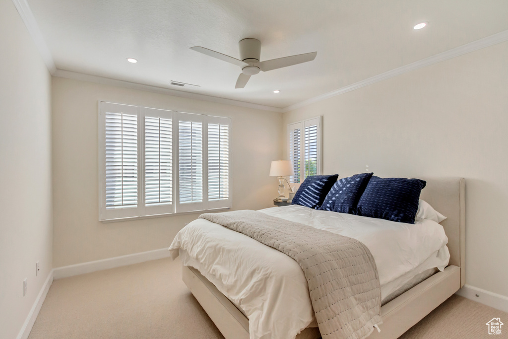 Carpeted bedroom featuring crown molding and ceiling fan