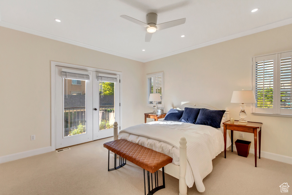 Bedroom with crown molding, light colored carpet, access to exterior, and ceiling fan