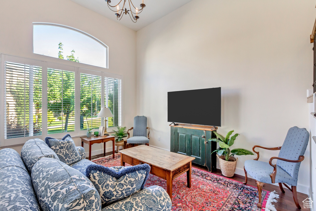 Living room featuring hardwood / wood-style floors, high vaulted ceiling, and an inviting chandelier