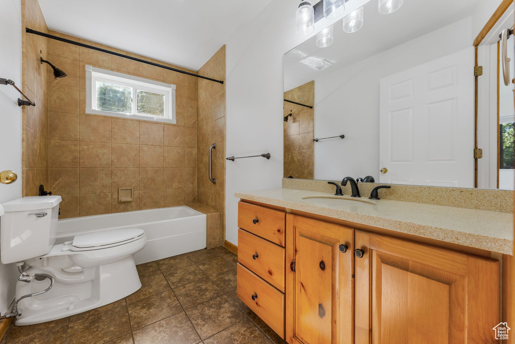 Full bathroom featuring vanity, toilet, tiled shower / bath, and tile patterned flooring