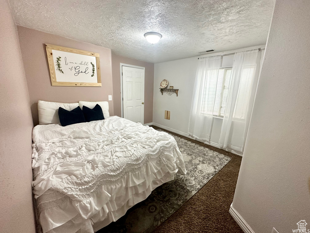 Carpeted bedroom featuring a textured ceiling